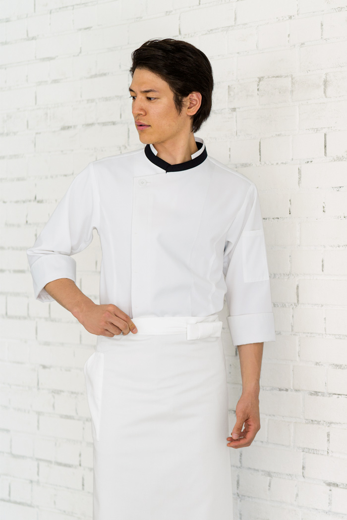 飲食店・サービス制服ユニフォームはコーディネートから選ぶ コラボレーションで作られた機能的で上品なコックコートに白の長め丈エプロンの組み合わせ。襟元の紺が全体を引き締めてくれる洗練された雰囲気の飲食店制服コーデ